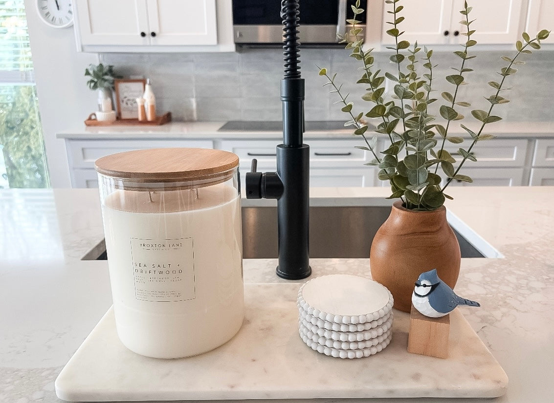 Candle, decorative items, and plant on a kitchen counter