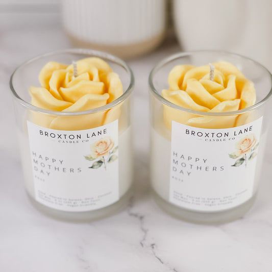 Two Broxton Lane candles with rose-shaped wax on a marble surface.
