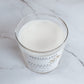 Glass candle with a label on a marble surface