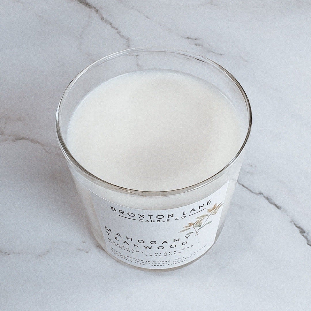 Glass candle with a label on a marble surface