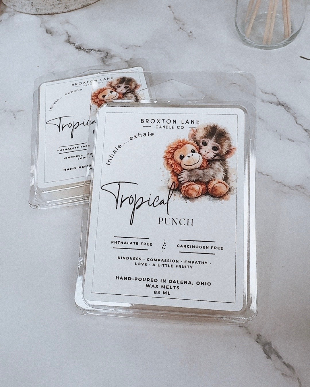 Broxton Lane candle packaging with lion and monkey design on a marble surface